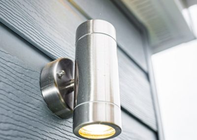 Cylinder Outdoor Light on a Home Extension with Blue Cladding